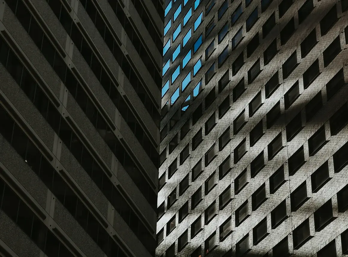 Night façade of an office building in dark and lit blue tones