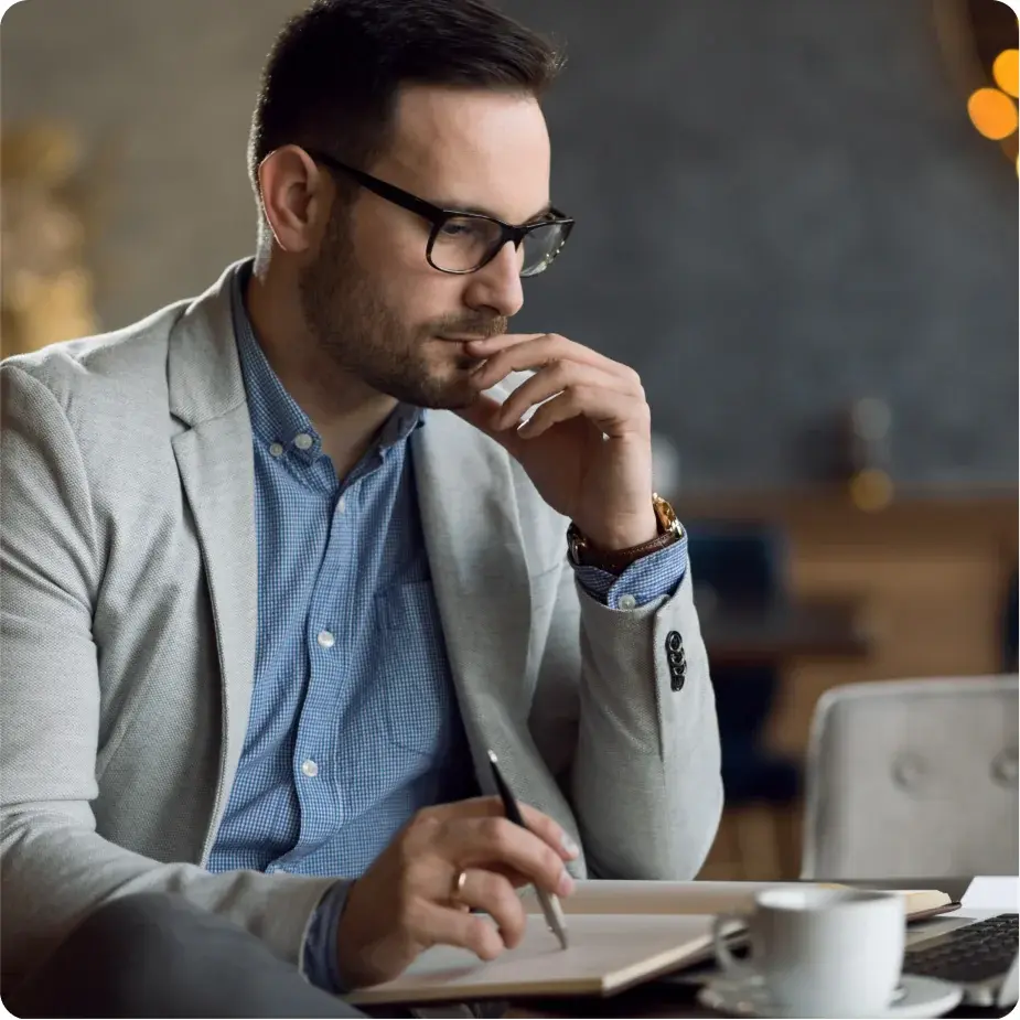 A man in a suit reading on a laptop